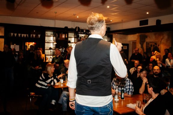 Person spricht vor einem Publikum in einem gemütlichen Restaurant.